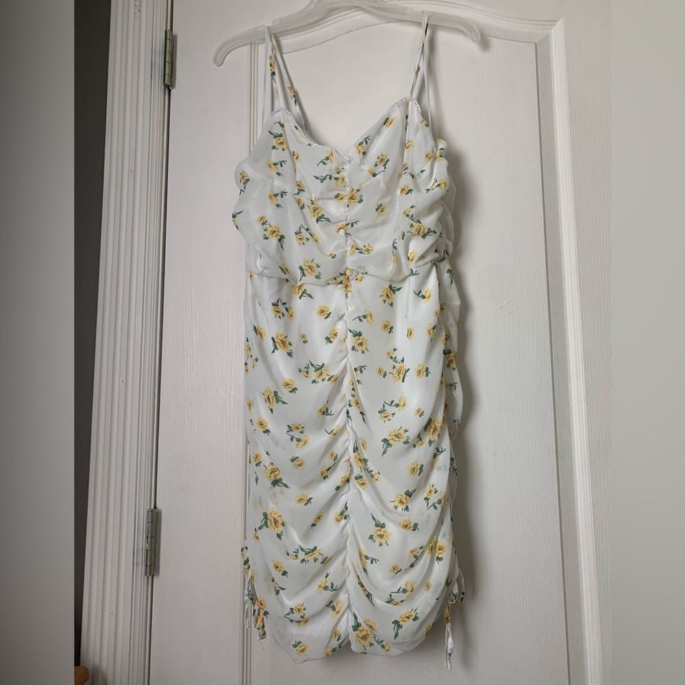 This is a white dress with yellow flowers on it.A great dress for warm weather!